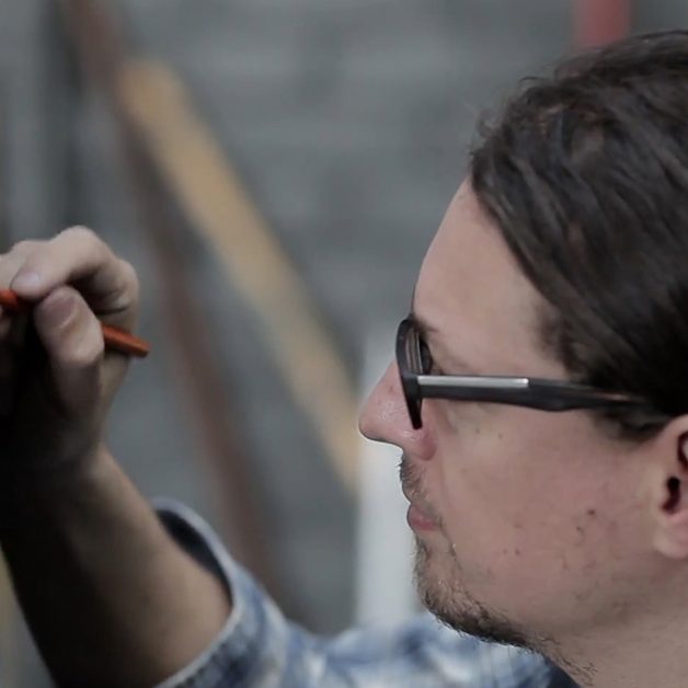 Artist David Kassan is drawing a portrait with a Charcoal Pencil.