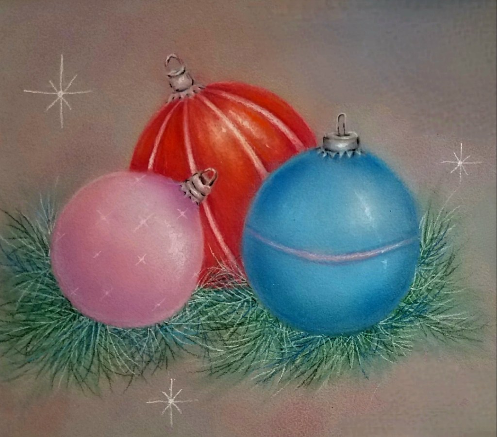 Three shiny Christmas ornaments—one pink, one red, and one blue—sit nestled on green pine needles, with star-like sparkles scattered around them on a soft, muted background.